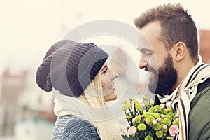 Picture showing young couple with flowers dating in the city