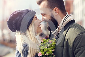 Picture showing young couple with flowers dating in the city