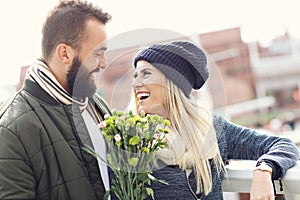 Picture showing young couple with flowers dating in the city