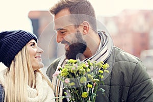 Picture showing young couple with flowers dating in the city