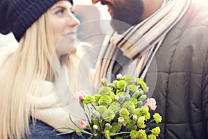 Picture showing young couple with flowers dating in the city