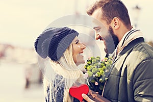 Picture showing young couple with flowers dating in the city