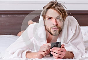 Picture showing young man stretching in bed. Feet of man sleeping in comfortable bed. Wake up morning.