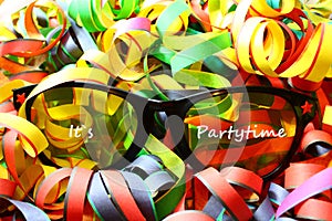 Glasses with the text it`s partytime and paper streamers
