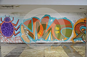 A graffiti with spider and letters on a wall