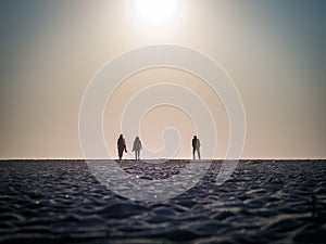 Picture of the silhouettes of two women and one man walking