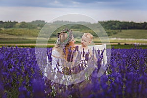 It is a picture of a small girl with her mother wearing a lavender wreath