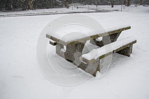 A picture of the snow-covered picnic table on the ground.