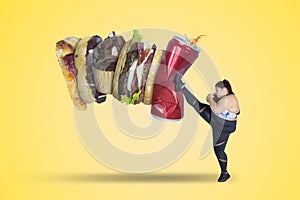 Strong woman kicking unhealthy meals