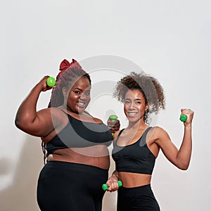 Picture of two afro women holding dumbbells