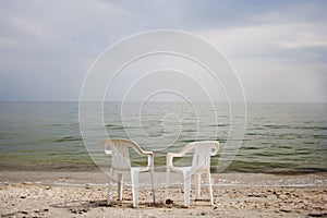 Picture of two chairs standing on seaside beach near calm sea