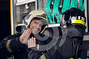 Picture of two firemen men making handshake near fire truck