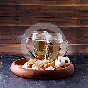 Picture of two mugs of beer and hot dogs on wooden tray