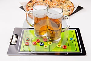 Picture of two mugs of beer, table football, pizza