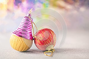 Picture of two New Year`s balls and pink Christmas bell on multicolor background with spots