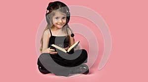 The picture of a very cute little girl posing while she was reading a very interesting book and she has a pair of