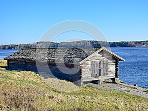 Picture of a very old stone house, fragments of wooden tile roof photo