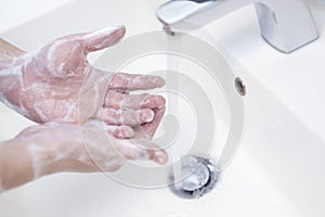 Washing hands rubbing with soap and water.