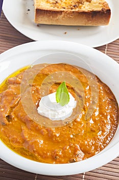 A picture of a white bowl full of fresh tomatoes soup