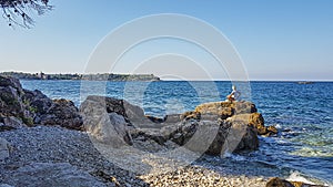 Picture of a woman doing yoga on a rock by the sea