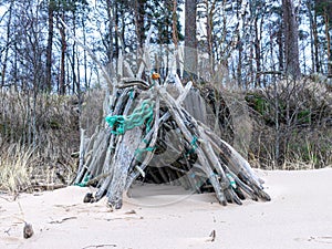 Picture with wooden branch hut by the sea