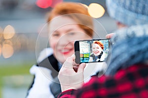 picture of wpman in smart-phone on the street. Portrait of woman in cellular-phone camera.Close up of smart-phone
