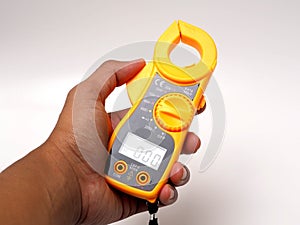 Picture of yellow digital clamp meter that using for measuring electrical current, voltage and resistance