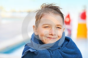 Picture of young boy in towel after playing in outdoor aqua park