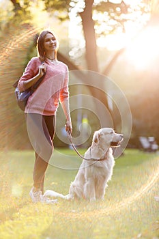 Picture of young brunette on walk with dog in summer park