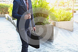 Picture of a young business man walking forward with a briefcase