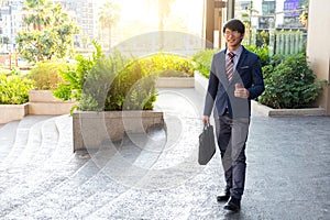 picture of a young business man walking forward with a briefcase