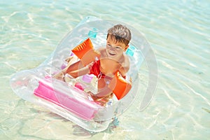 Picture of young happy boy swimming on mattress on Red Sea