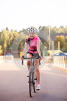 Picture of young woman in helmet on bike ride on summer day