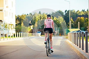 Picture of young woman in helmet on bike ride on summer day