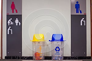 Picture for your concept yellow trash is general waste and blue is recyclable waste in front of the bathroom inside the airport