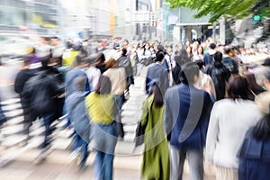 picture with zoom effect of a crowd of people crossing a street in the city