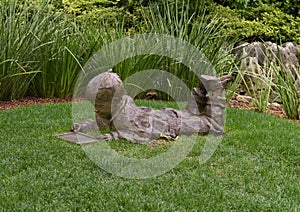 Bronze sculpture of a boy with an etch a sketch by Gary Price at the Dallas Arboretum and Botanical Garden