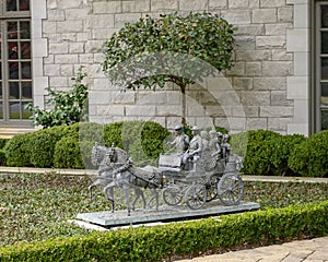 Detailed bronze sculpture of a horse drawn carriagne in the front of a mansion in Highland Park, Dallas, Texas.