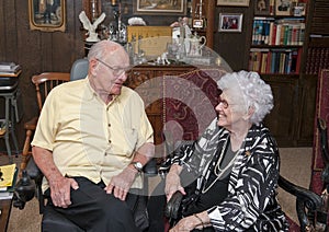 Elderly couple celebrating wife`s 86th birthday in their home as they share an affectionate look.