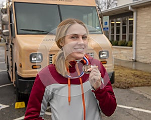 Forty-seven year old woman posing with her medal after running the Edmond Turkey Trot in Edmond, Oklahoma