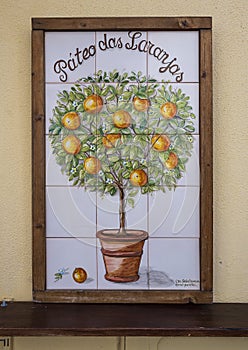 Hand-painted tiles with an orange tree in a planter on a business in Sintra, Portugal. photo