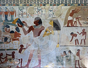 Fresco with Nakht pouring water on the table of offerings and his wife Tawy standing behind him in tomb TT52.
