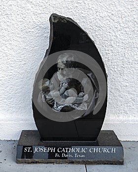 Image of Saint Joseph holding infant Jesus in front of the Historic Saint Joseph Catholic Church in Fort Davis, Texas.