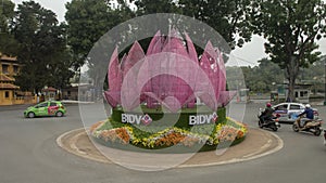 Flowers and abstract light purple geometric installation in a traffic circle in hanoi, vietnam