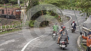 Motorcycles with passengers restarting after stopping for the train to pass, Hai Van Pass, Vietnam