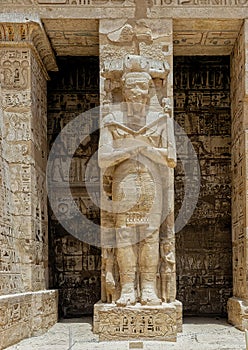 Osiride statue of Ramesses III being attended to by little queens on the right side of the first court of his Mortuary Temple. photo