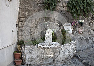 Ornate drinking fountain with small statue of a cherub holding a dolphin, Marina Grande, Sorrento