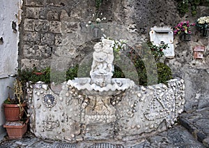 Ornate drinking fountain with small statue of a cherub holding a dolphin, Marina Grande, Sorrento