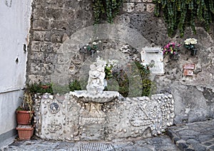 Ornate drinking fountain with small statue of a cherub holding a dolphin, Marina Grande, Sorrento