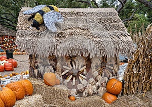 Photography spot with hay bales, pumpkins, and a straw house in the pumpkin patch at the Dallas Arboretum in Texas.